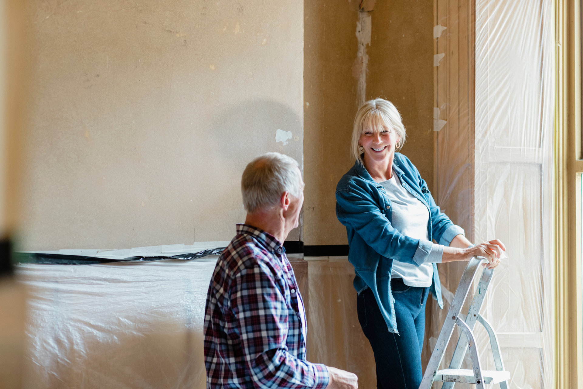 Senior male and female renovating building and in one of the rooms.